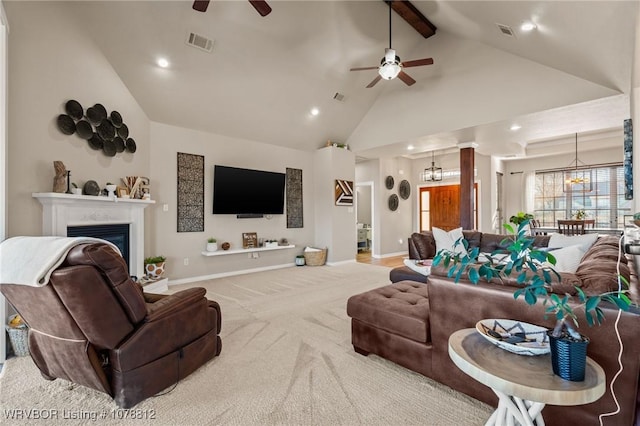 carpeted living room featuring ceiling fan with notable chandelier, high vaulted ceiling, and beamed ceiling