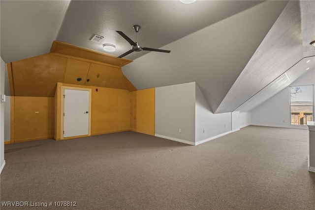 additional living space with lofted ceiling, a textured ceiling, ceiling fan, and carpet flooring