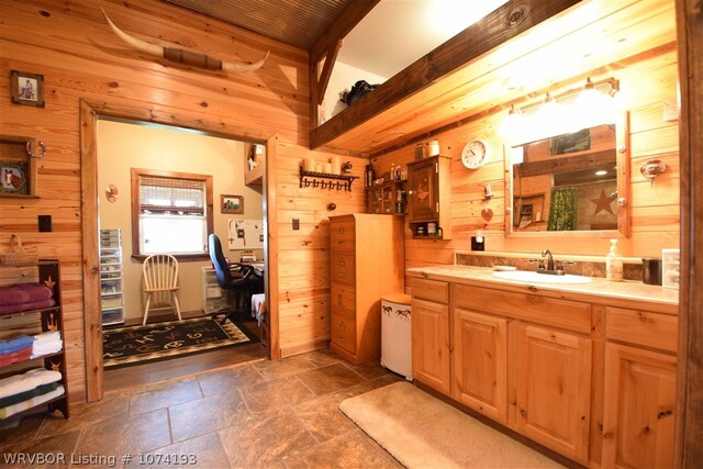 bathroom featuring vanity and wood walls