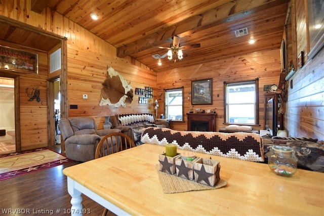 dining room with wooden ceiling, lofted ceiling with beams, wooden walls, ceiling fan, and wood-type flooring