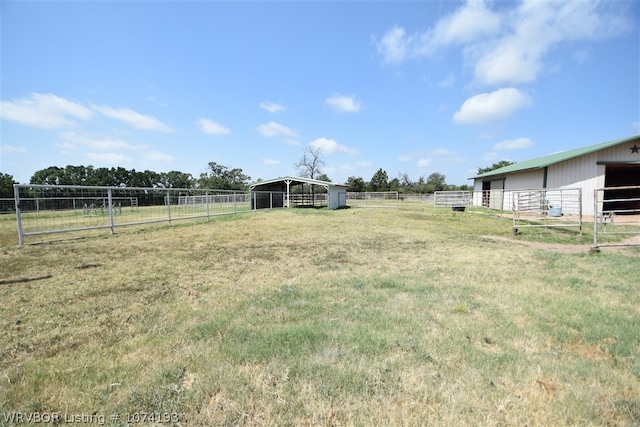 view of yard featuring a rural view and an outbuilding