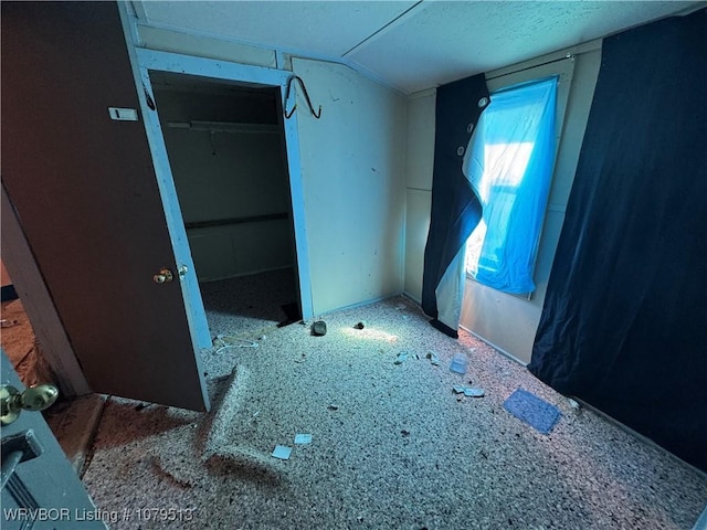 unfurnished bedroom featuring a closet and lofted ceiling