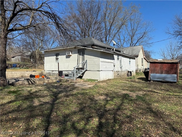 view of property exterior featuring an outbuilding, entry steps, and a yard