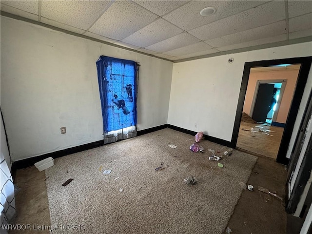 unfurnished room featuring baseboards and a drop ceiling