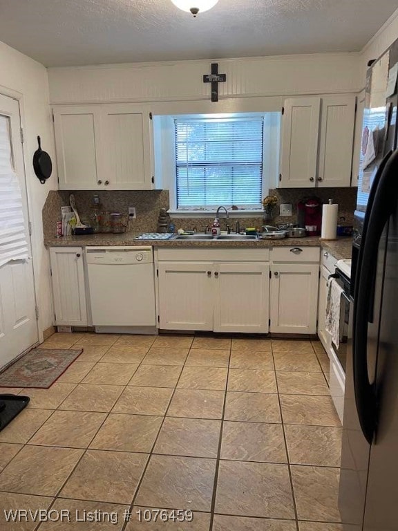 kitchen with white dishwasher, white cabinets, electric stove, sink, and light tile patterned flooring