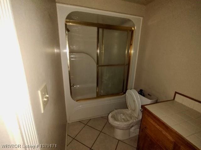 bathroom with tile patterned flooring, vanity, toilet, and bath / shower combo with glass door