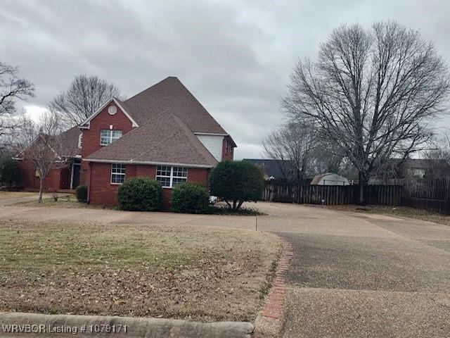 view of side of property with fence and a yard