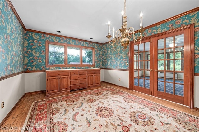 2017 S 70th St, Fort Smith, AR 72903 - unfurnished dining area featuring french doors, a chandelier, wainscoting, wood finished floors, and wallpapered walls