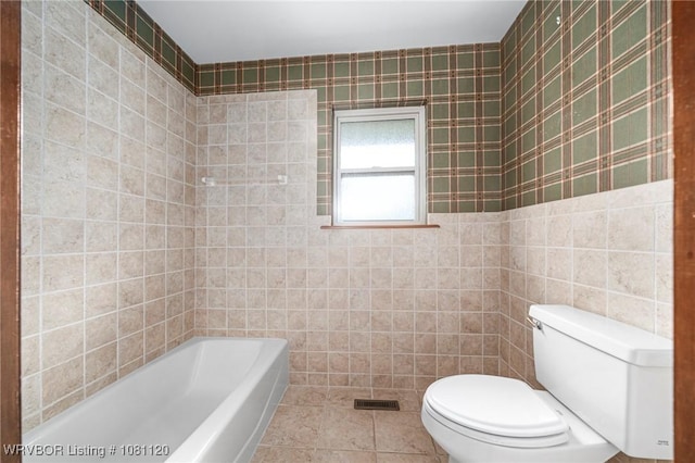 2017 S 70th St, Fort Smith, AR 72903 - bathroom featuring toilet, a tub to relax in, tile walls, and tile patterned floors