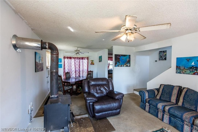 carpeted living room featuring ceiling fan and a textured ceiling