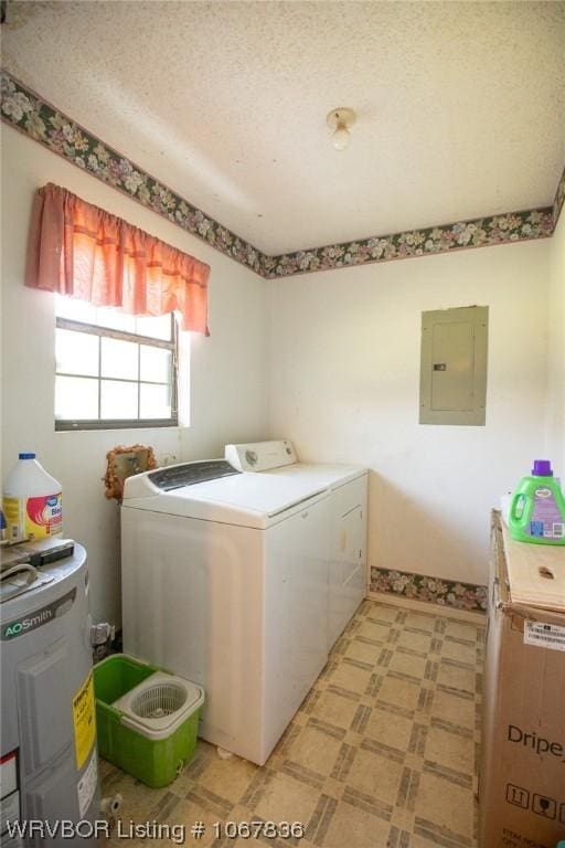 washroom with electric panel, electric water heater, a textured ceiling, and washing machine and dryer