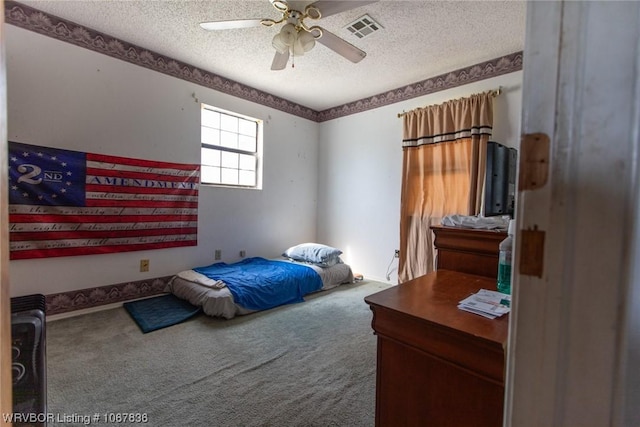 carpeted bedroom featuring ceiling fan and a textured ceiling