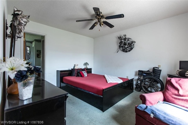 bedroom with ceiling fan, carpet floors, and a textured ceiling