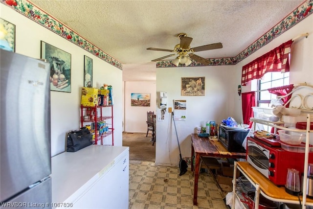 kitchen featuring ceiling fan, stainless steel fridge, refrigerator, and a textured ceiling