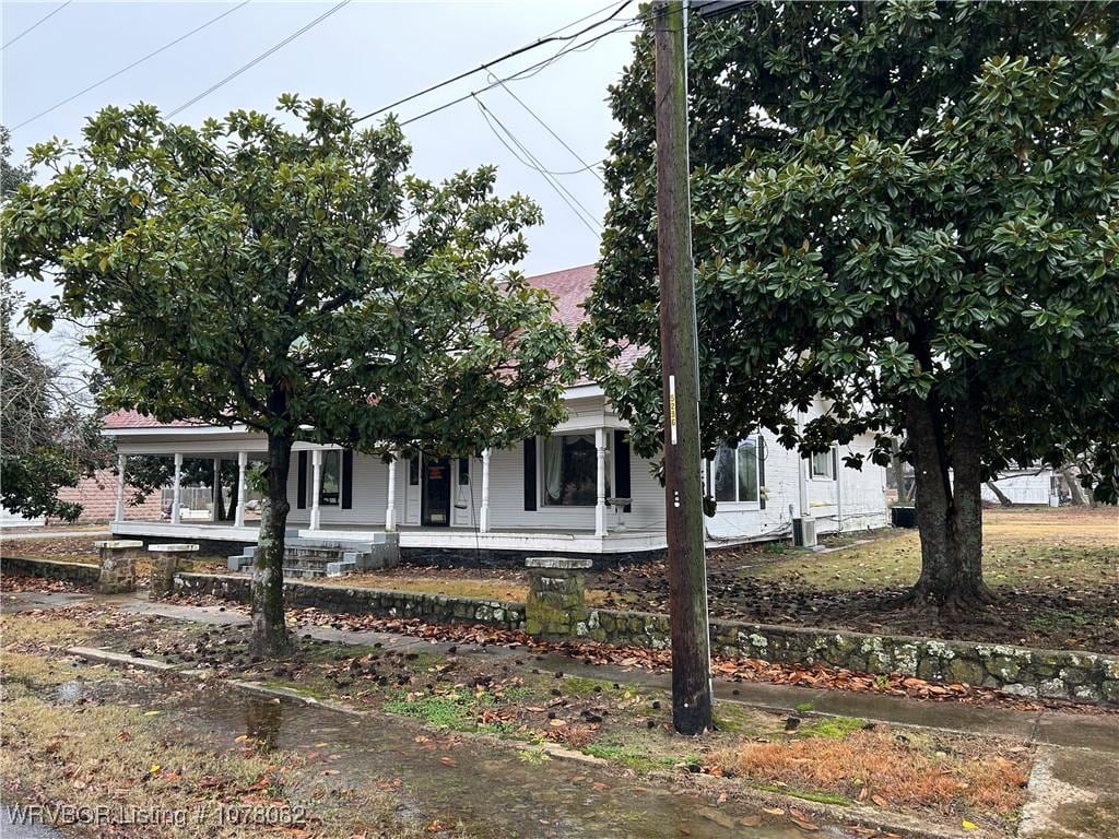 view of property hidden behind natural elements with a porch