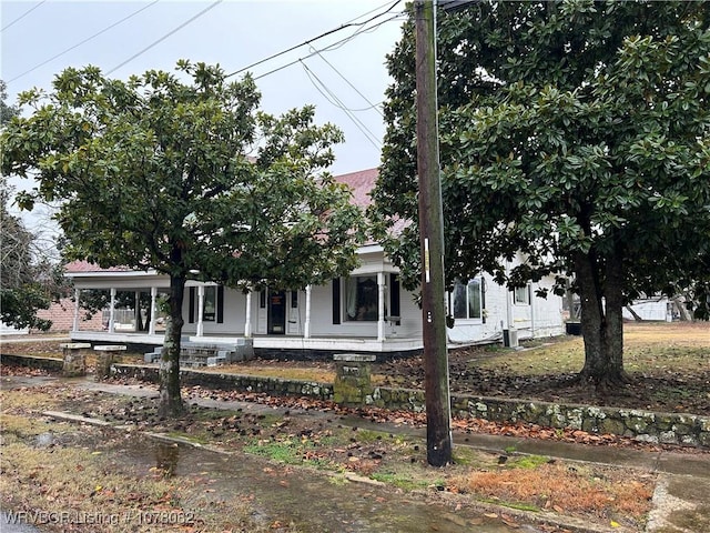 view of property hidden behind natural elements with a porch