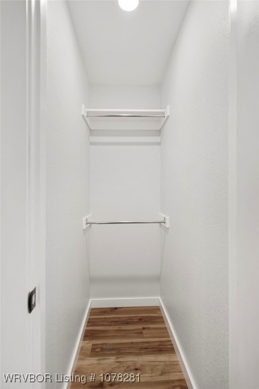 walk in closet with hardwood / wood-style flooring