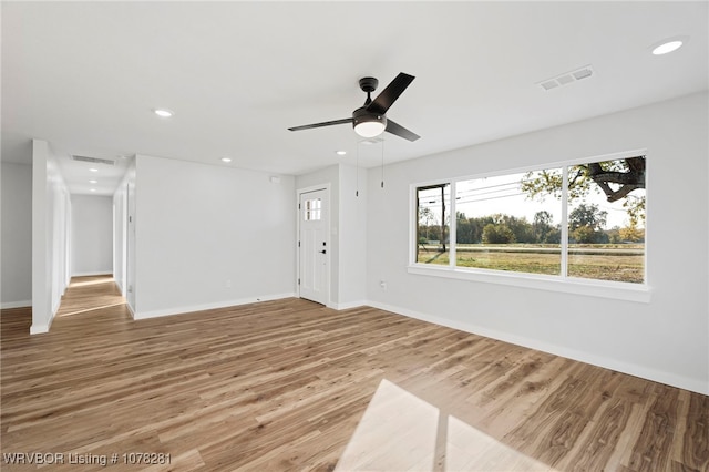 unfurnished living room featuring hardwood / wood-style flooring and ceiling fan