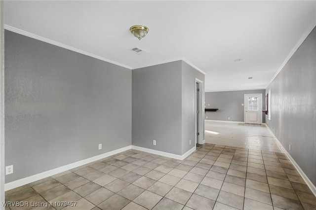 empty room with light tile patterned flooring, baseboards, visible vents, and ornamental molding