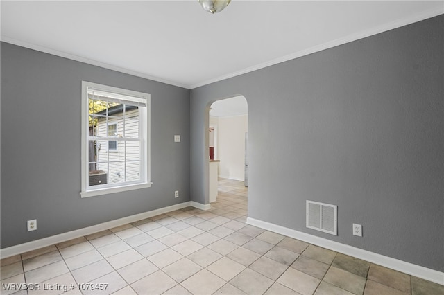 unfurnished room with arched walkways, visible vents, baseboards, and ornamental molding