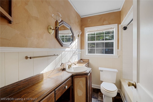 full bath with a wainscoted wall, tub / shower combination, toilet, and vanity