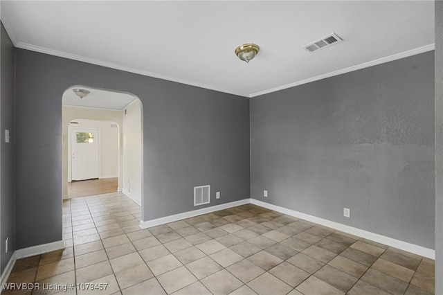 spare room with crown molding, arched walkways, and visible vents