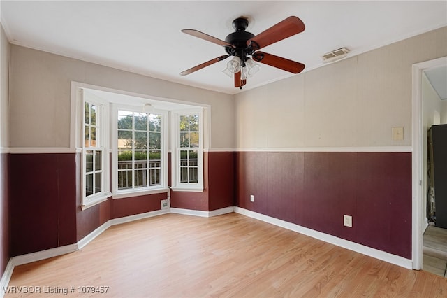 spare room with visible vents, baseboards, a ceiling fan, and wood finished floors