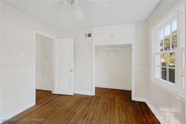 unfurnished bedroom featuring visible vents, baseboards, a closet, and wood finished floors