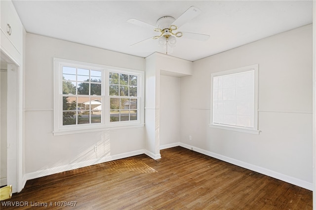 unfurnished room featuring a ceiling fan, wood finished floors, and baseboards