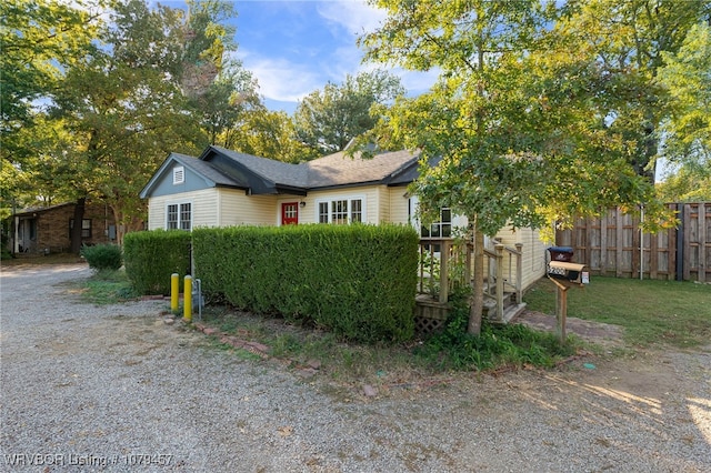 view of front of home featuring driveway and fence