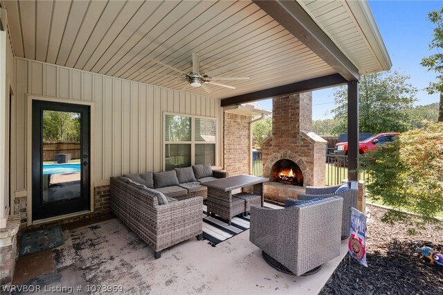 view of patio / terrace with an outdoor living space with a fireplace and ceiling fan