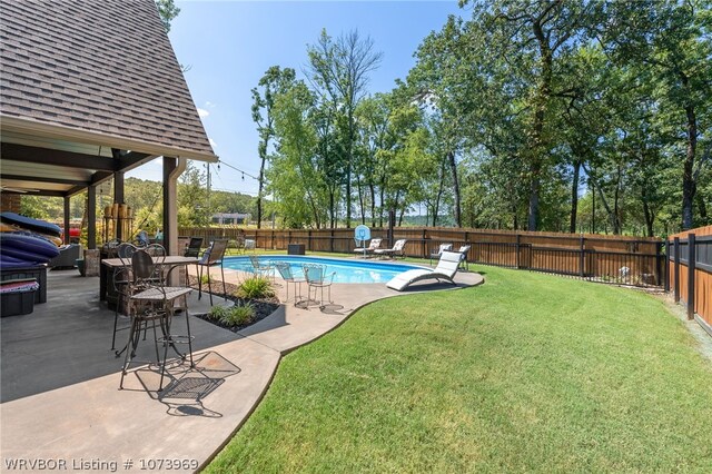 view of swimming pool featuring a patio area and a yard