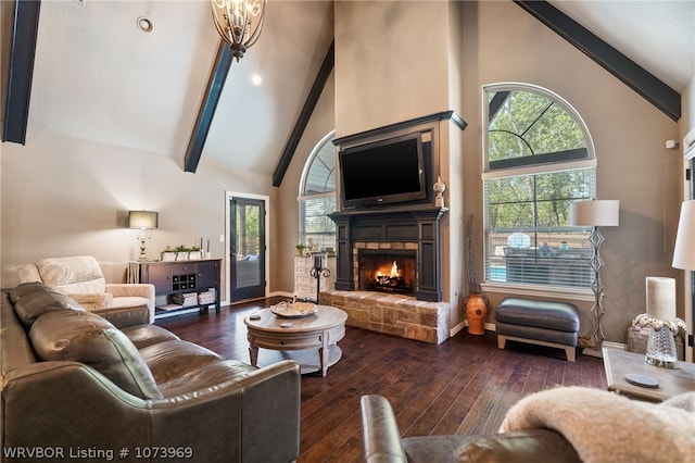 living room featuring beam ceiling, high vaulted ceiling, a stone fireplace, and dark wood-type flooring