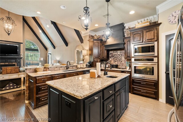 kitchen with a center island with sink, stainless steel appliances, and sink