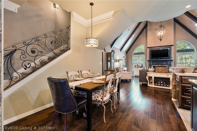 dining area with vaulted ceiling with skylight, wood-type flooring, and a notable chandelier