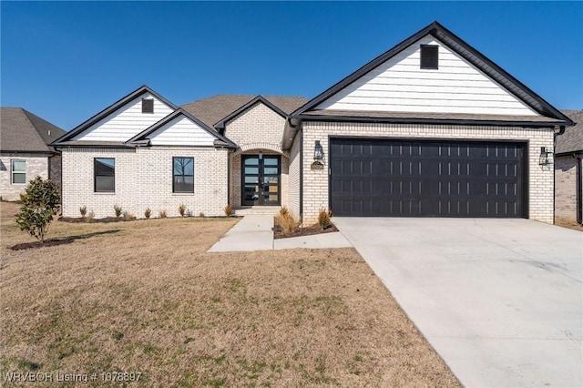 view of front facade featuring a garage, a front yard, concrete driveway, and brick siding