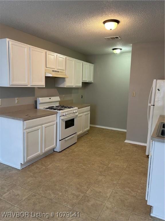 kitchen featuring white appliances, baseboards, visible vents, white cabinets, and under cabinet range hood