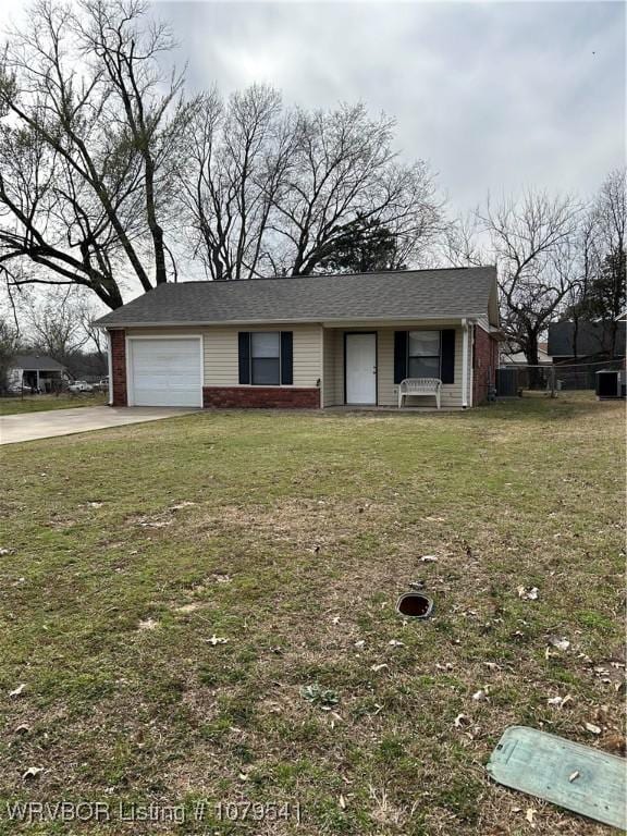 view of front of house featuring a front yard, an attached garage, brick siding, and driveway