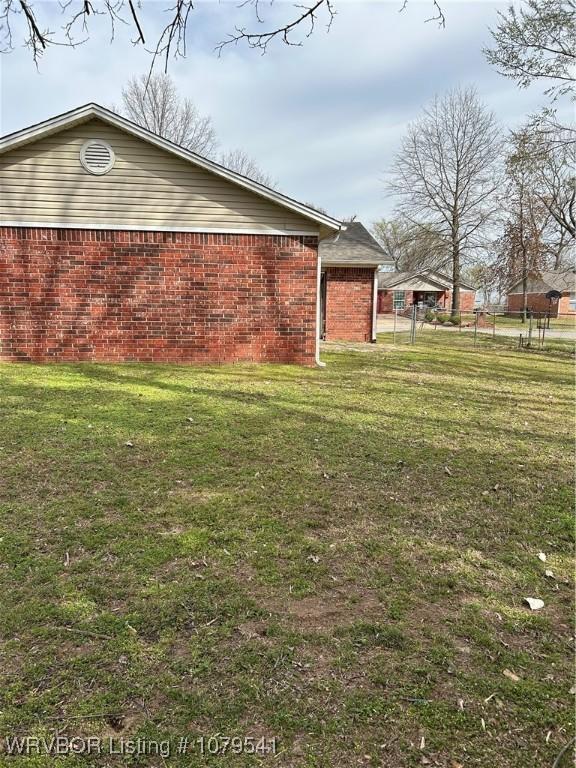 view of home's exterior with a lawn and brick siding