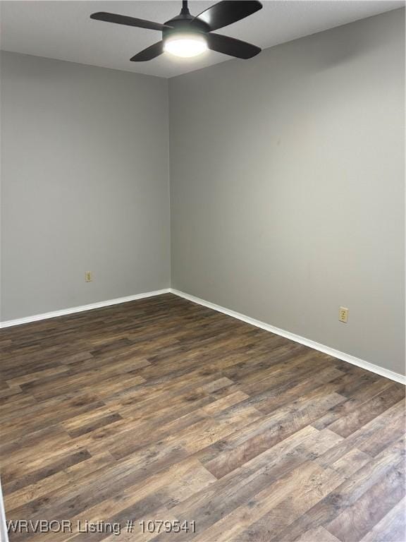 empty room featuring dark wood finished floors, baseboards, and ceiling fan