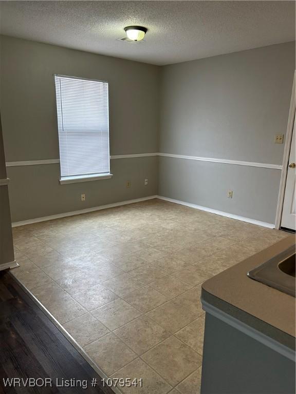 interior space with baseboards and a textured ceiling