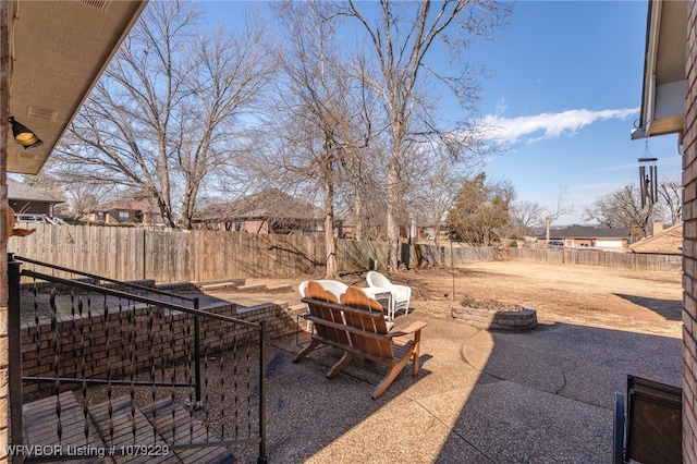 view of yard featuring a fenced backyard, a fire pit, and a patio