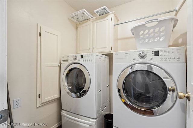 laundry area with washing machine and clothes dryer and cabinet space