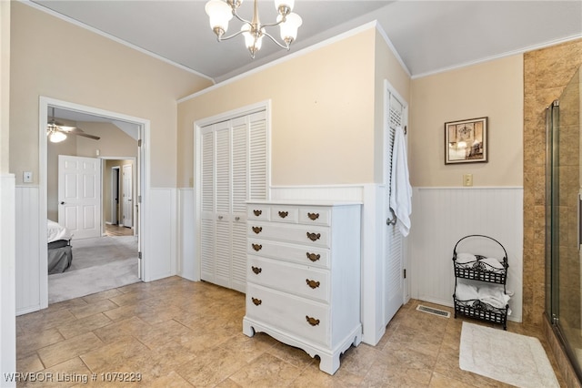 hall featuring a chandelier, a wainscoted wall, visible vents, and ornamental molding