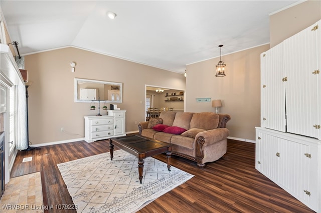 living room with crown molding, a fireplace with flush hearth, vaulted ceiling, wood finished floors, and baseboards