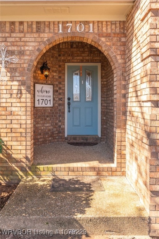 view of exterior entry with brick siding