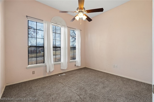 carpeted spare room with visible vents, ceiling fan, and baseboards