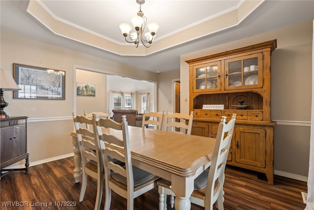 dining room with baseboards, a raised ceiling, dark wood finished floors, and a notable chandelier