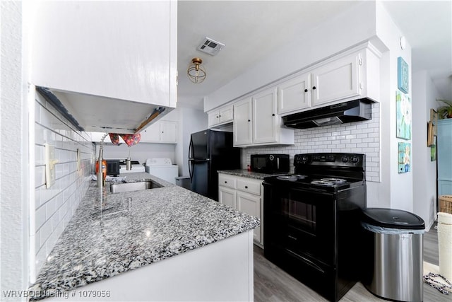 kitchen with white cabinetry, light stone counters, decorative backsplash, and black appliances