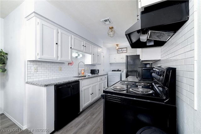 kitchen featuring sink, white cabinetry, extractor fan, black appliances, and washer and dryer